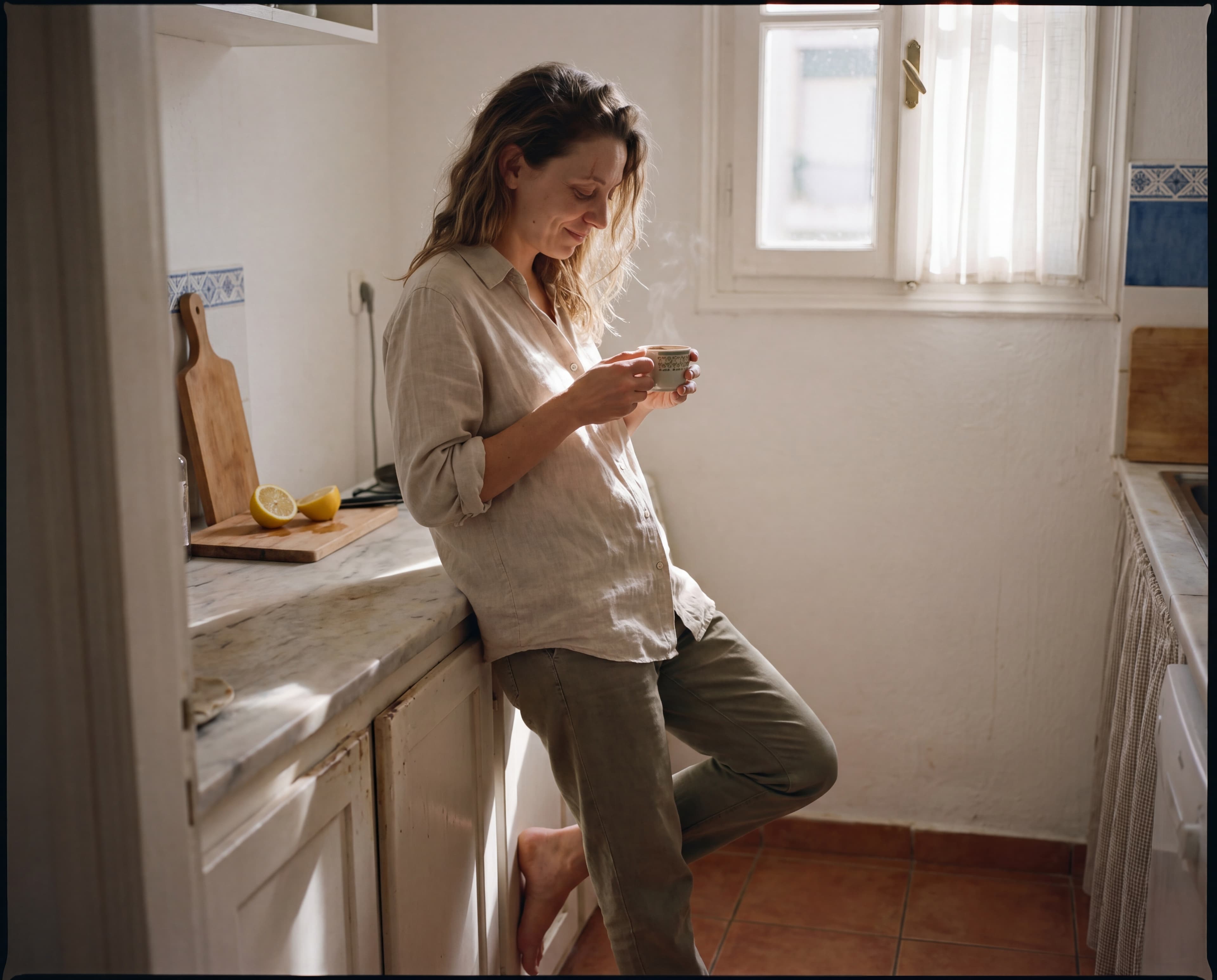 Woman seated on the floor by a window in afternoon light
