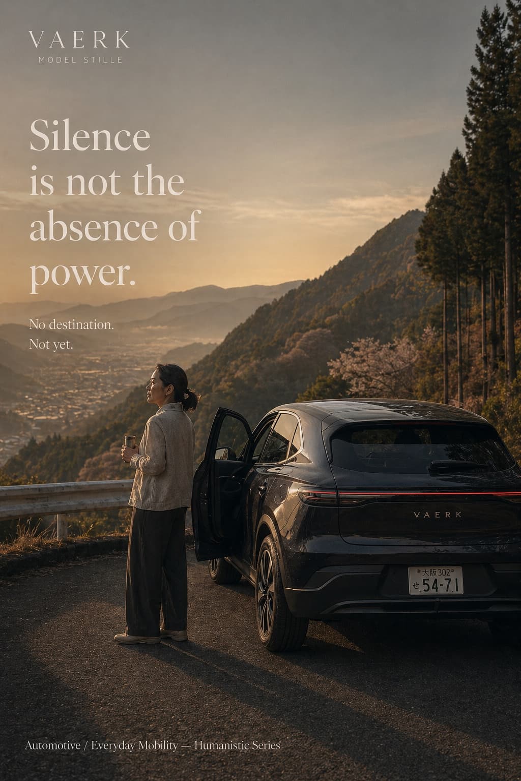 A Vaerk Model Stille on an Osaka mountain road at dusk, a woman beside it taking in the valley